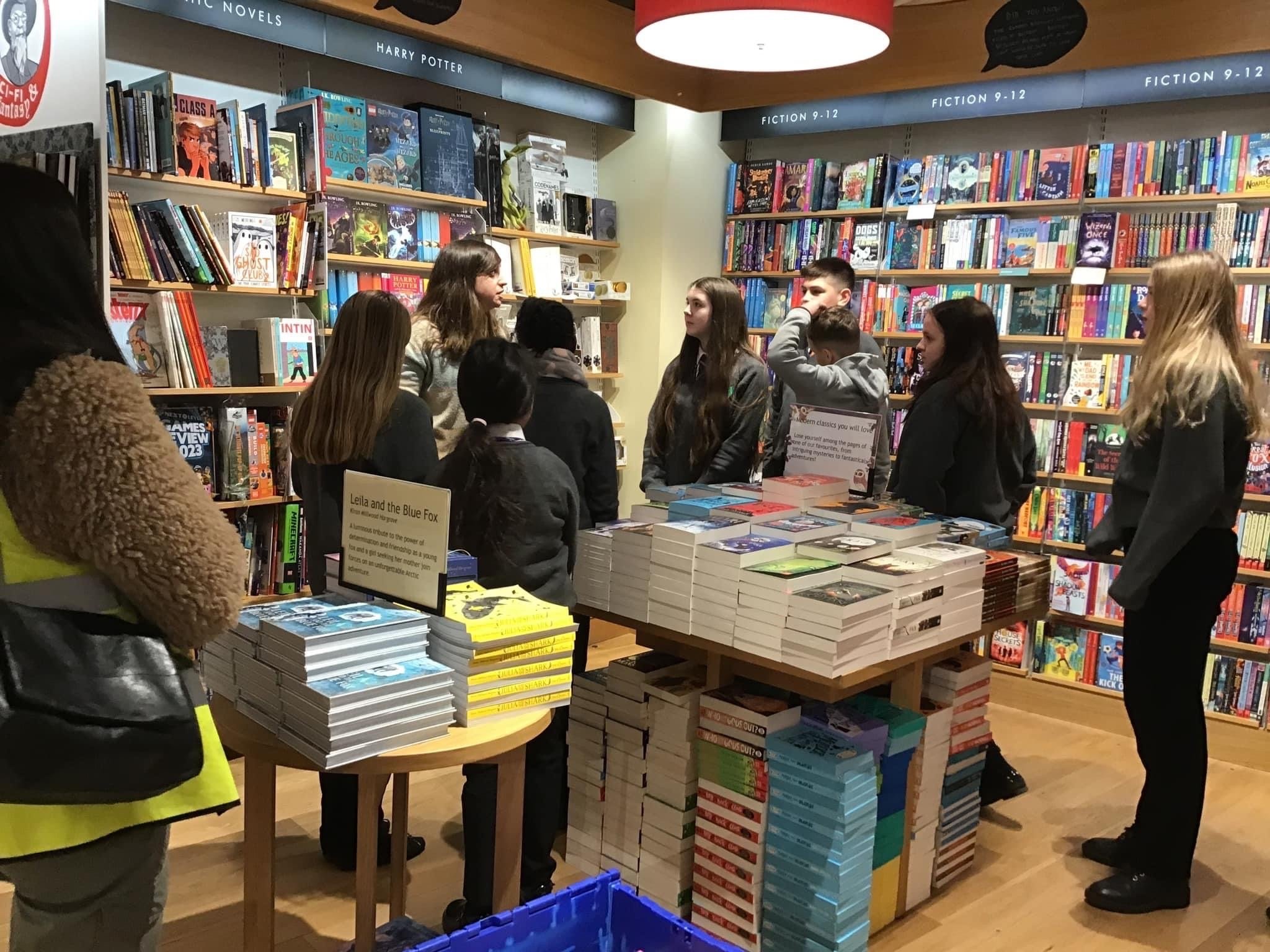 A group of 9 students stood in the corner of a book shop, while on a school trip