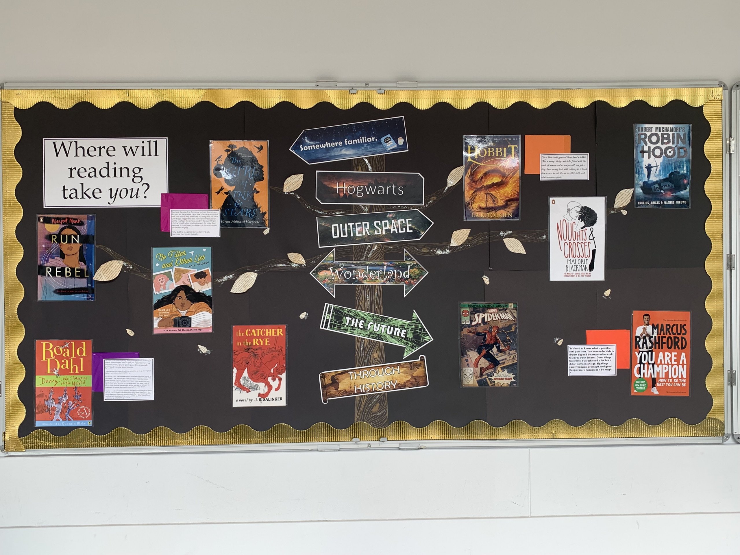 A classroom wall display with a variety of book covers on it